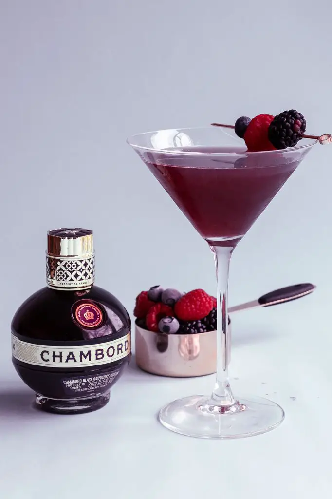Chambord Martini garnished with berries and fresh fruits on the white background