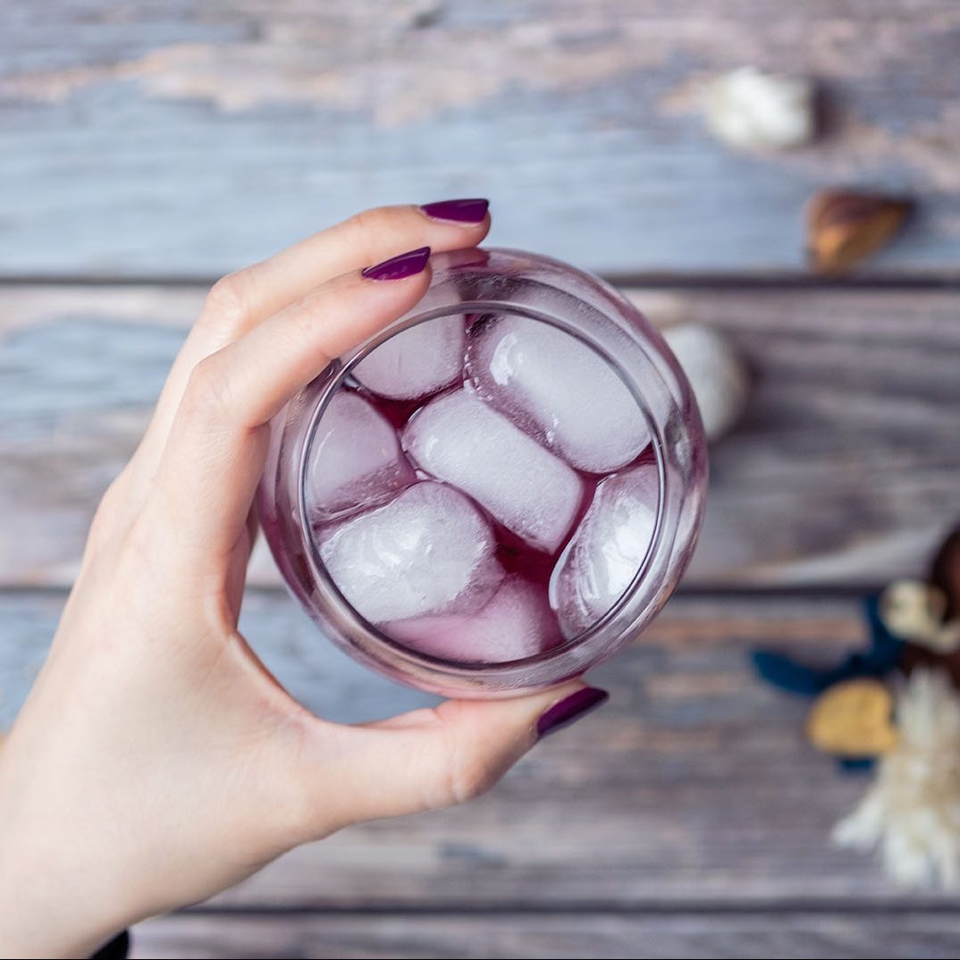 hand holding a purple cocktail