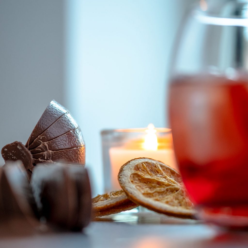 Orange chocolate on the back, blurry image of a glass filled with ice and Negroni on the front.